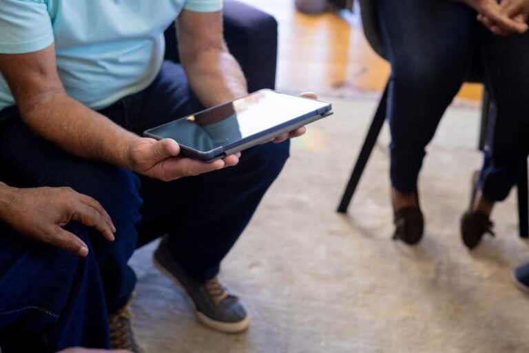 Person seated holding a tablet
